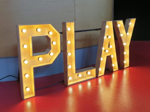 Lichtletters in die het Engelstalige woord "Play" vormen
